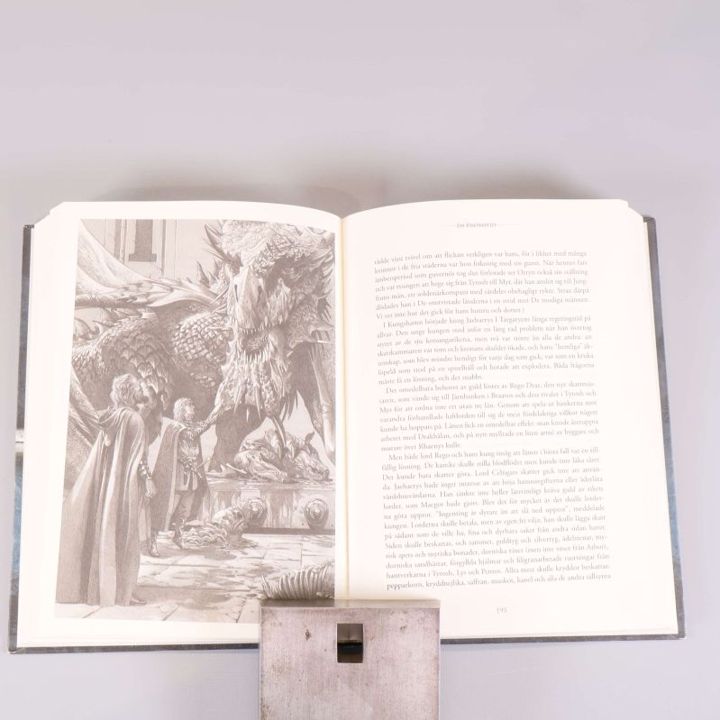 Uppslag från boken med illustration av drake och text på svenska