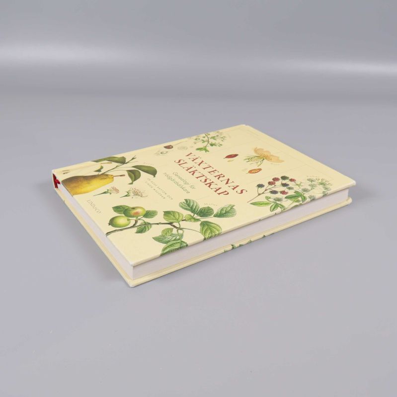 Boken Växternas släktskap liggande snett med pärmens motiv synligt
