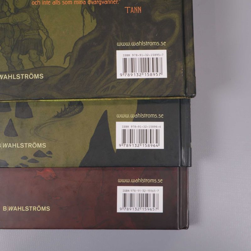 Tre bokbaksidor med synliga ISBN-nummer och förlagsinformation