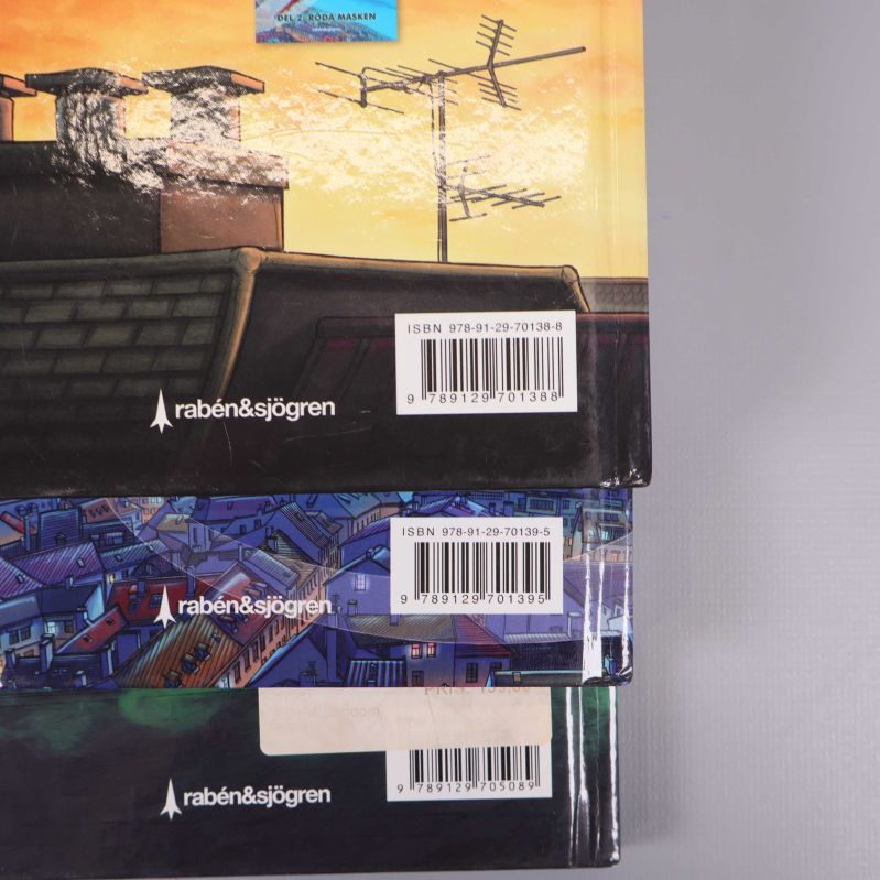 Närbild på tre bokbaksidor med ISBN till Handbok för superhjältar
