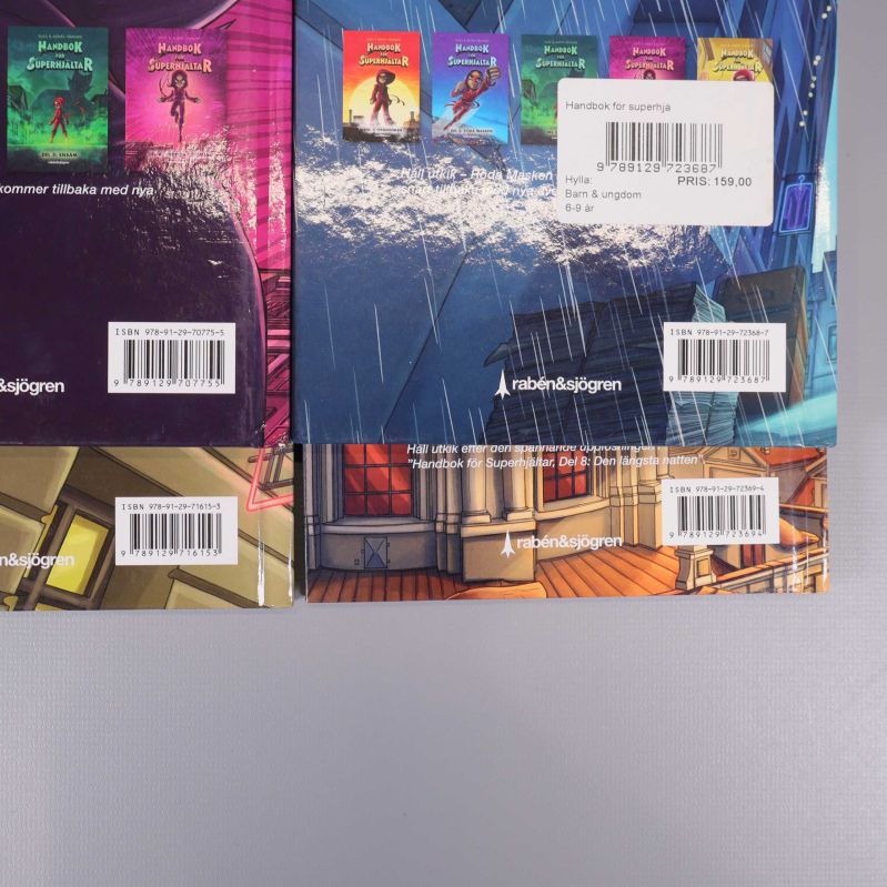 Närbild på fyra bokbaksidor med ISBN och etiketter