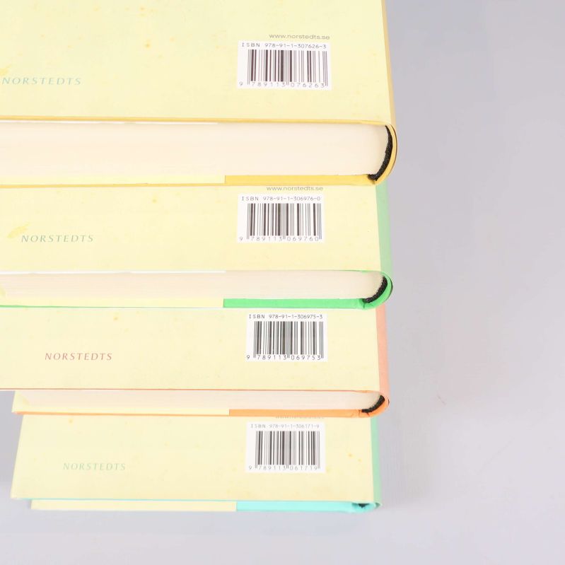Närbild på fyra böckers baksidor med synliga ISBN-streckkoder