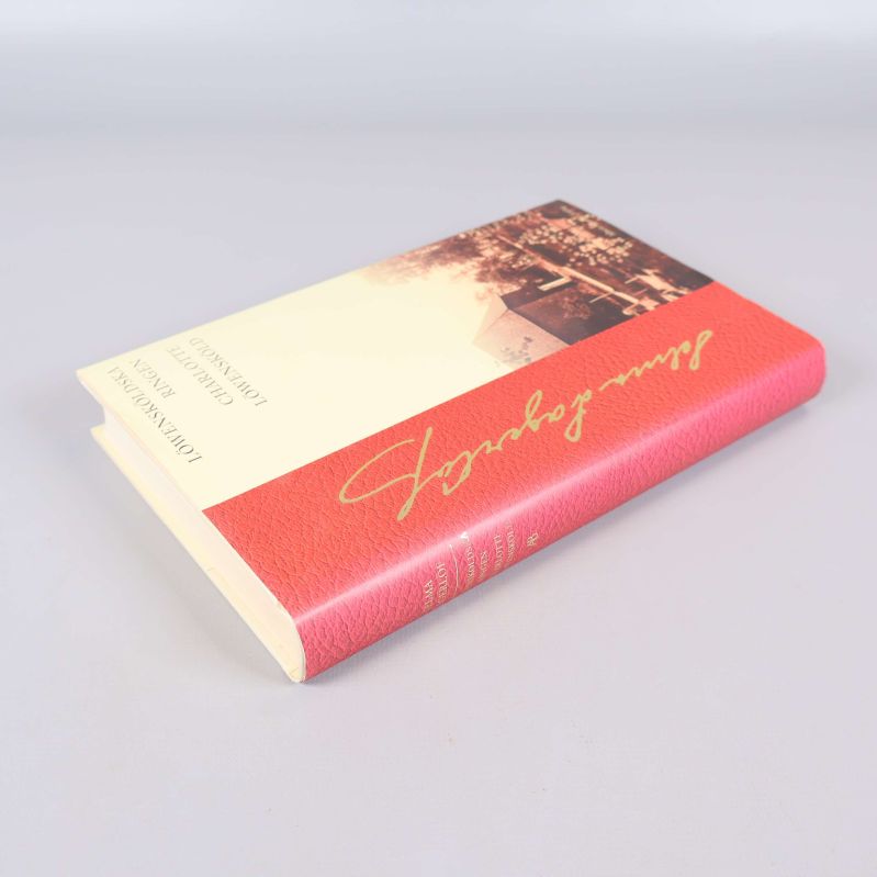 Boken liggande, visar detalj av omslaget och bokryggen