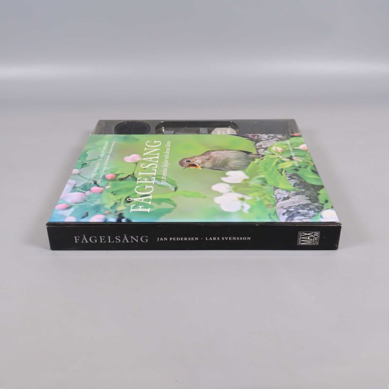 Fågelsång bok liggande, rygg synlig med titeln och författarnamn