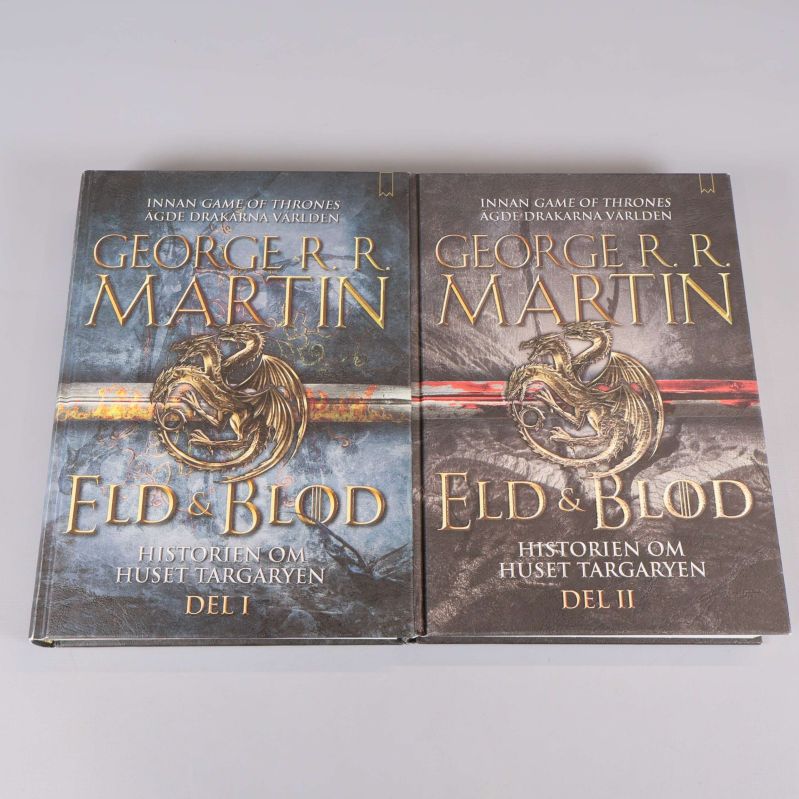 Två böcker Eld & Blod Del 1 och Del 2 av George R.R. Martin bredvid varandra med omslagen synliga