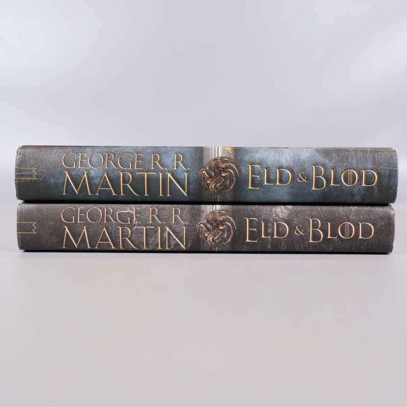 Ryggarna på Eld & Blod Del 1 och Del 2 av George R.R. Martin med tydlig guldtext och drakemblem