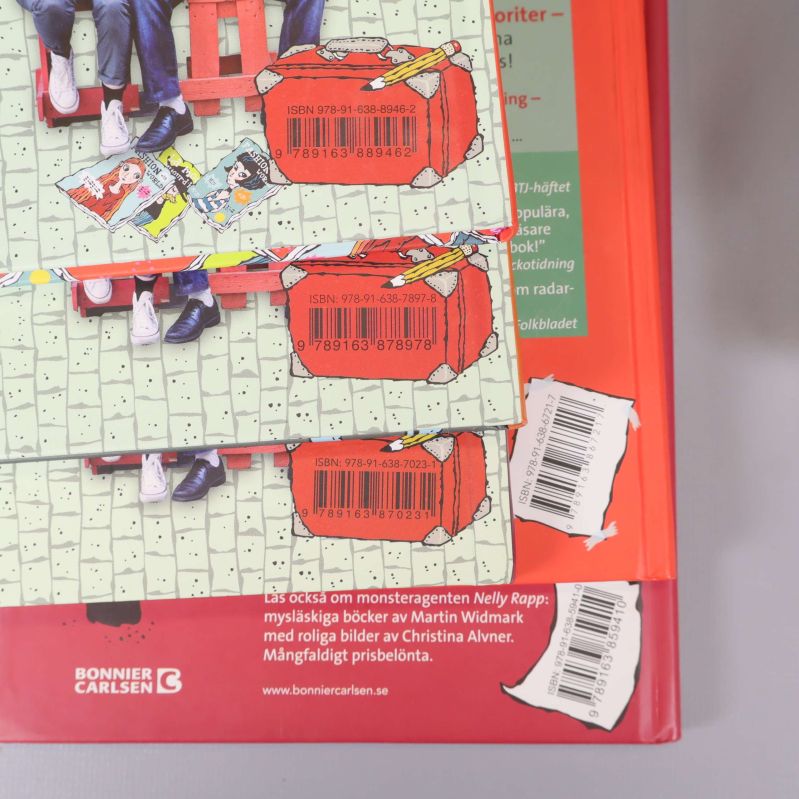 Närbild på baksidor av flera LasseMajas Detektivbyrå-böcker med ISBN