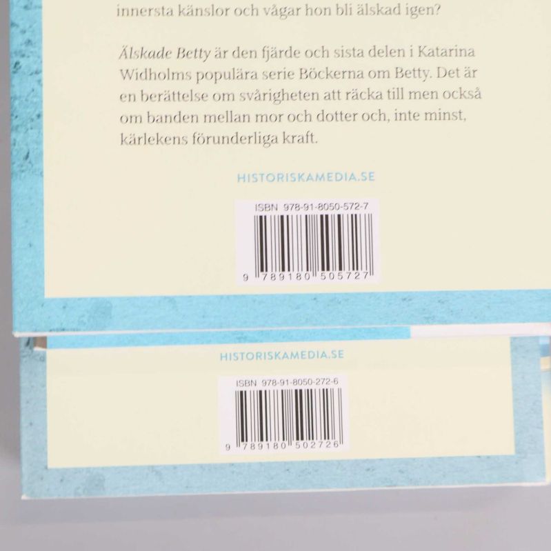 Närbild på två baksidor med ISBN, fokus på etiketter
