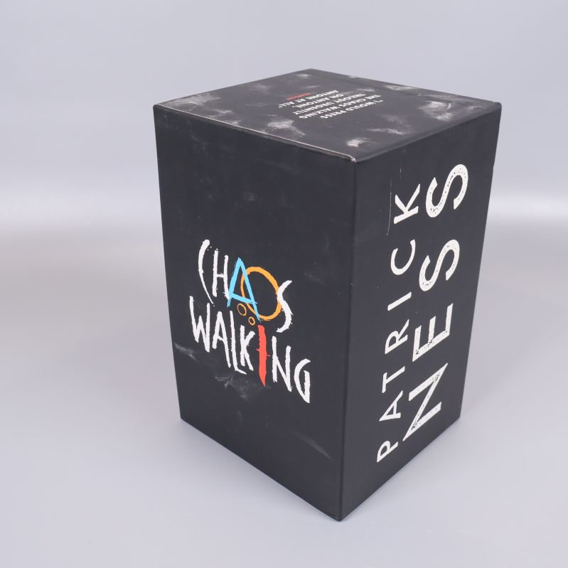 Svart box med Chaos Walking-loggan och Patrick Ness namn
