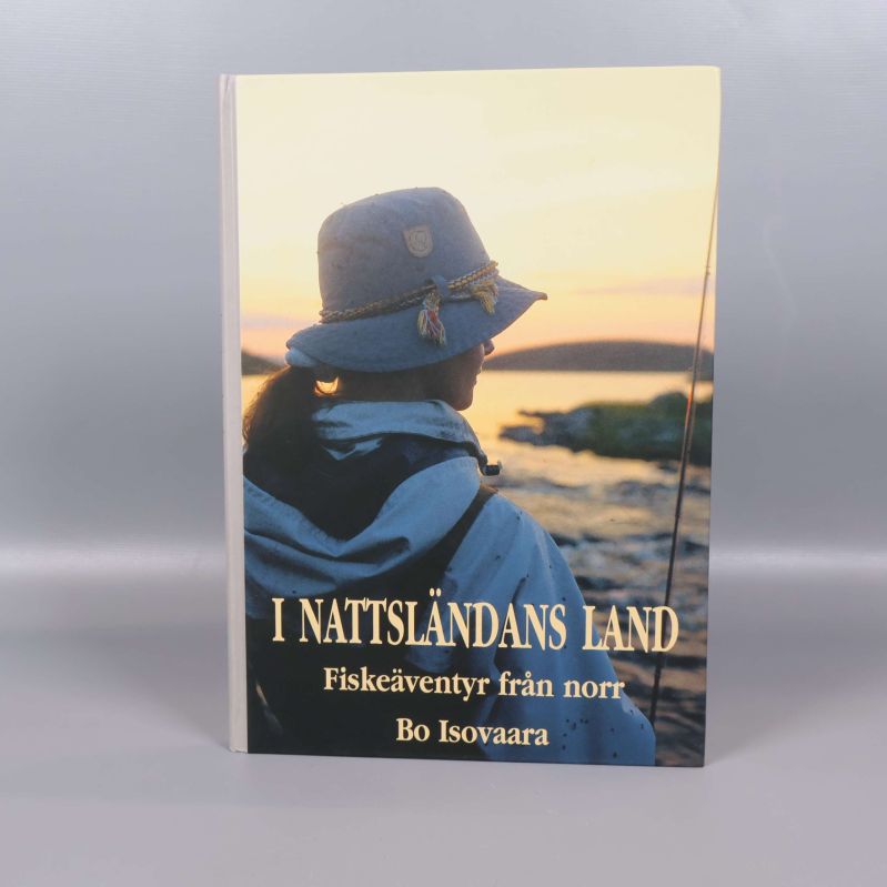 Framsidan av boken I nattsländans land med en person vid vattnet i solnedgång