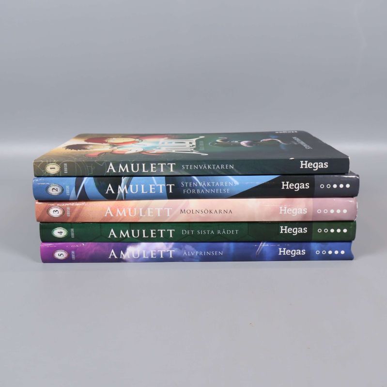 Amulett-böcker staplade med ryggarna synliga