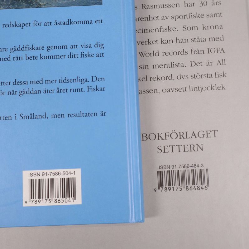 Närbild på bokrygg med båda böckernas ISBN-nummer och förlagsetiketter