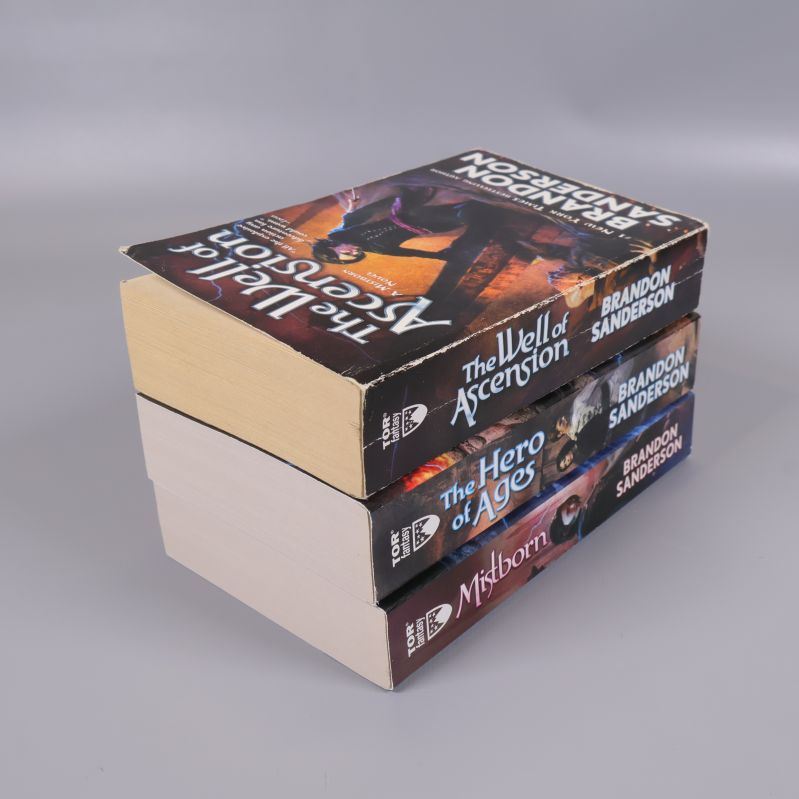 Tre Mistborn Trilogy böcker staplade med ryggarna synliga