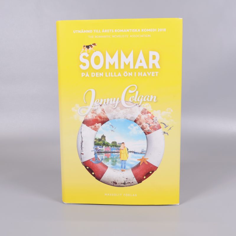 Framsida av Sommar på den lilla ön i havet med räddningsring och illustration av en hamn