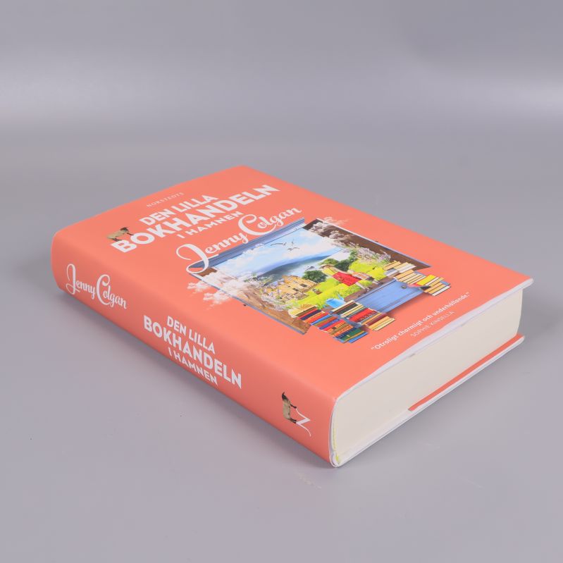 Boken Den lilla bokhandeln i hamnen i sned vinkel som visar ryggen