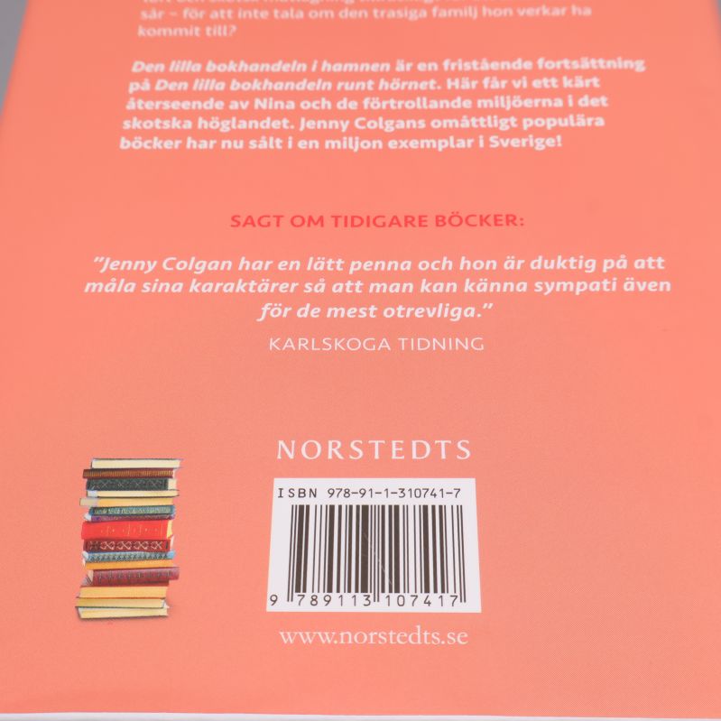 Närbild på baksidan visar ISBN och stapel med böcker