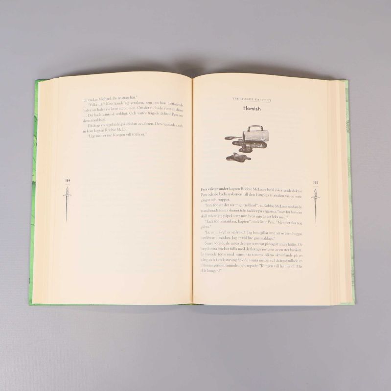 Uppslaget kapitel ur Smaragdernas bok med text och liten illustration