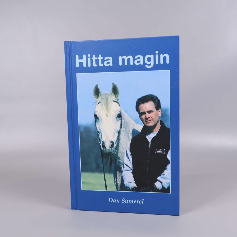 Bok med blått omslag, Hitta magin, står upp mot grå bakgrund