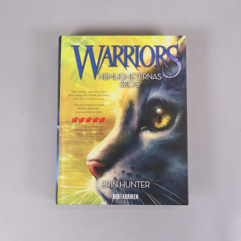 Framsidan av boken Warriors Hemligheternas skog med en katt och färgglad bakgrund
