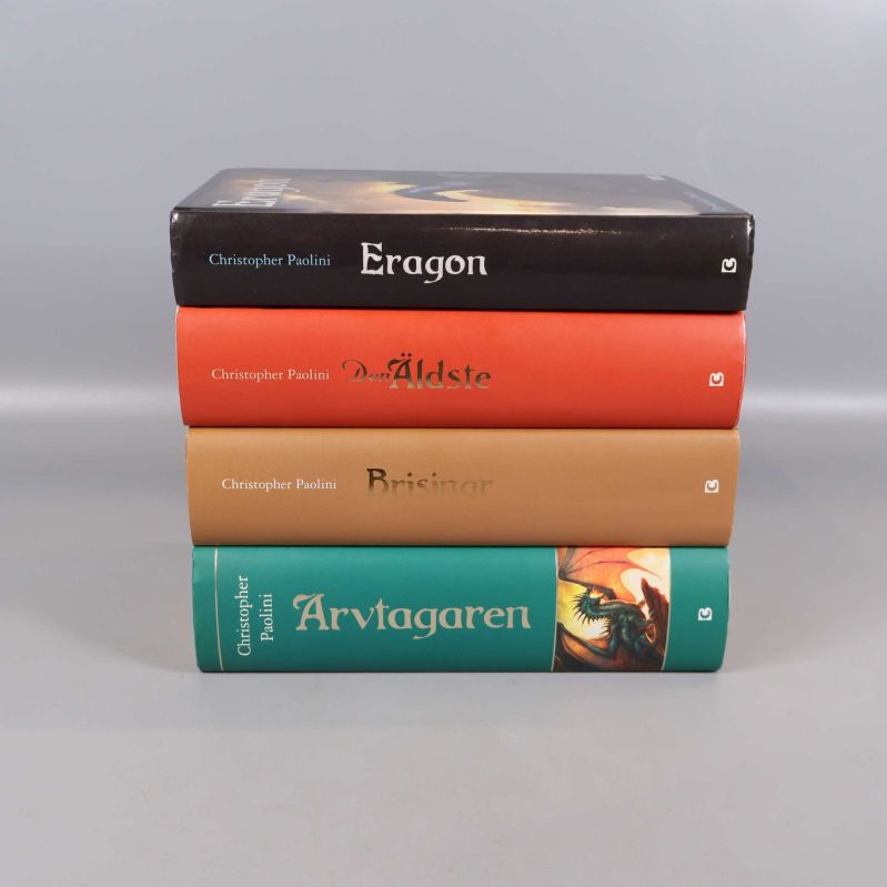 Eragon-böcker staplade med titlar och färgglada ryggar