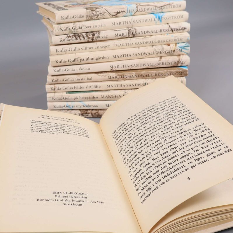 Uppslagen bok med ISBN och tryckuppgifter, fler Kulla-Gulla böcker syns i bakgrunden