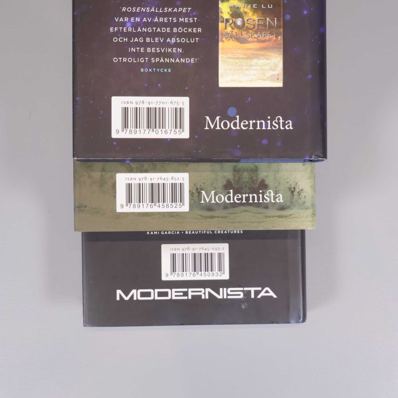 Närbild på baksideetiketter och ISBN-nummer på alla tre böcker