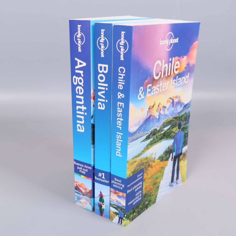 Tre Lonely Planet böcker stående i rad, fokus på ryggar