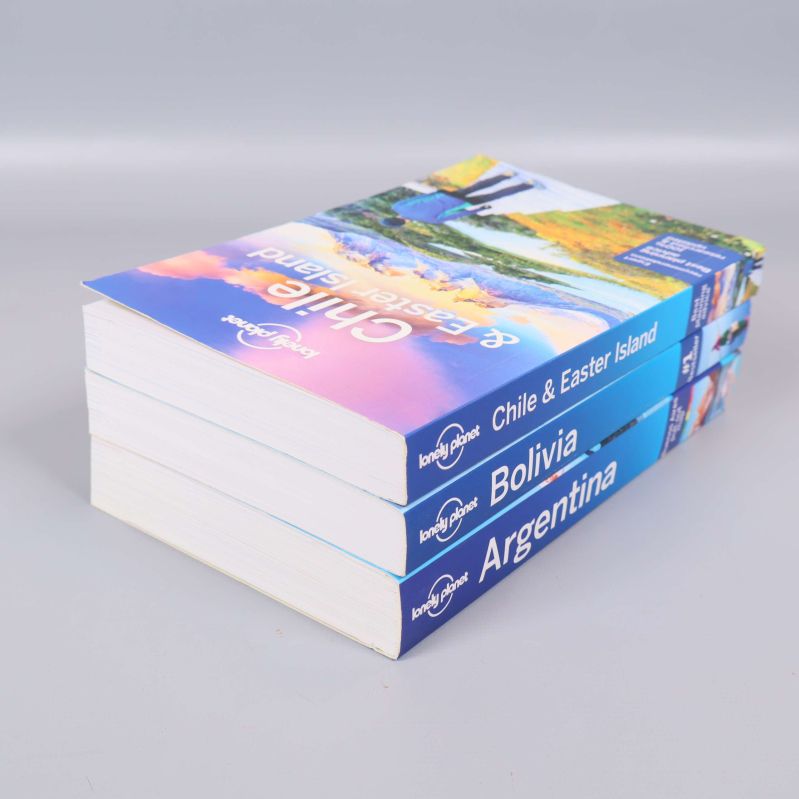 Tre Lonely Planet böcker staplade, titlar synliga på ryggarna
