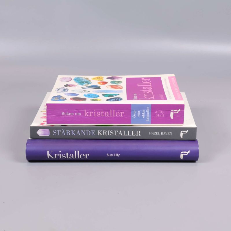 Tre staplade böcker om kristaller, vy från sidan och ryggen