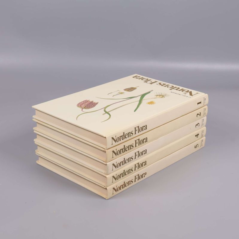 Nordens Flora bokpaket staplade, med övre bokens omslag synligt