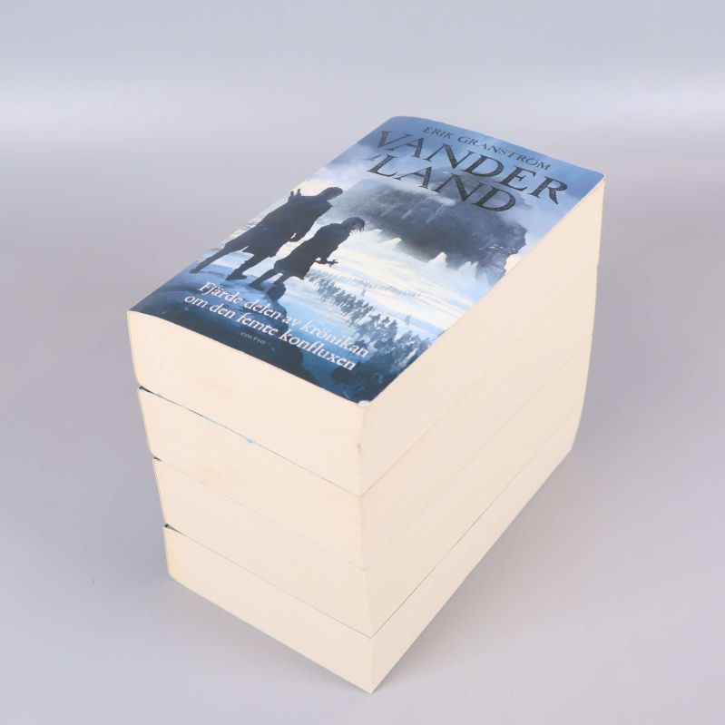 Överst bok i staplat paket, titeln Vanderland synlig