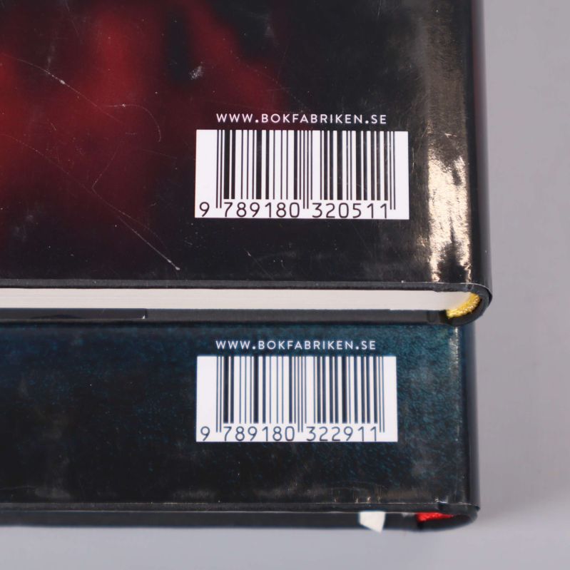 Närbild på streckkoder och ISBN på baksidan av båda böckerna