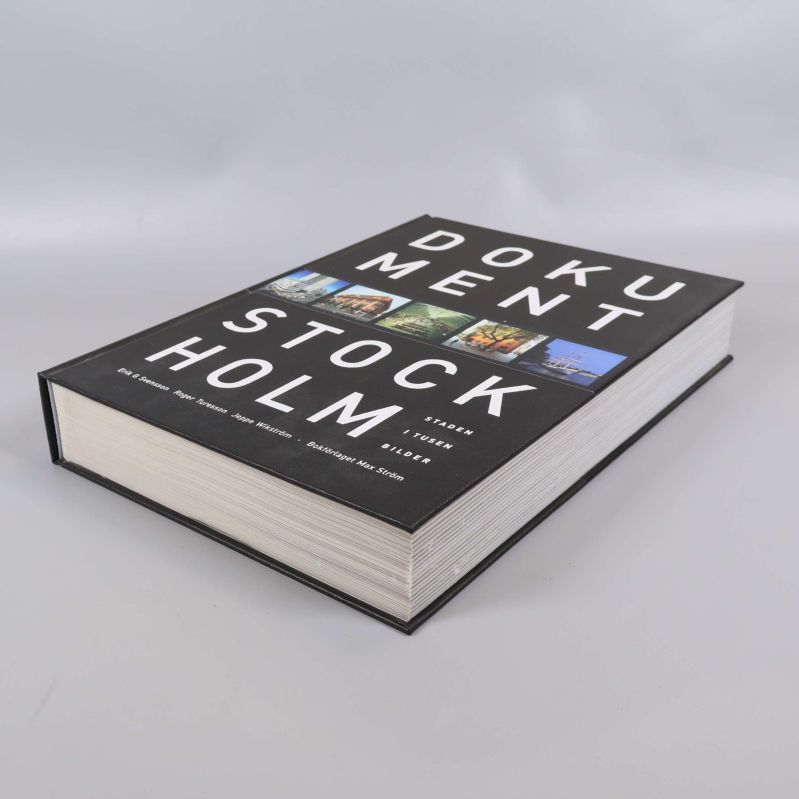 Boken liggande med fokus på de många sidorna och det grafiska omslaget