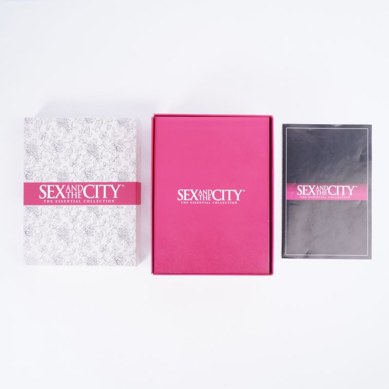 Sex and the City box, rosa fodral och skivpaket bredvid varandra