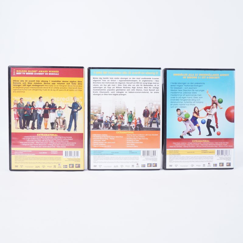 Baksidor av tre DVD-fodral från Glee box