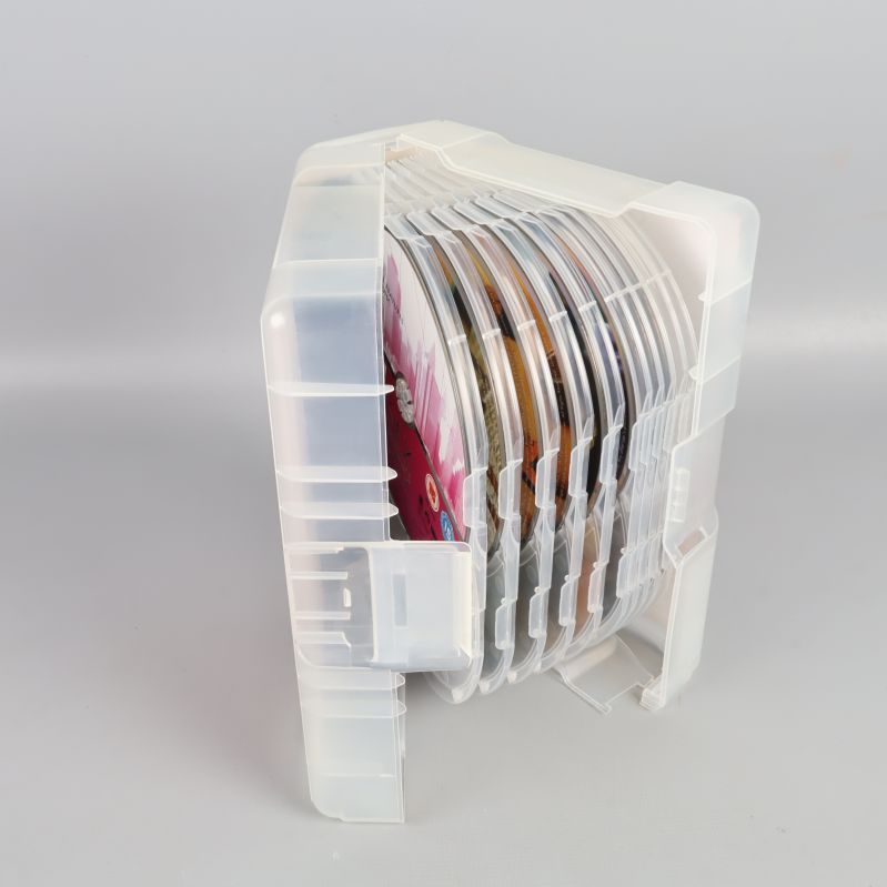 Öppen plastbox med flera DVD-skivor staplade på rad