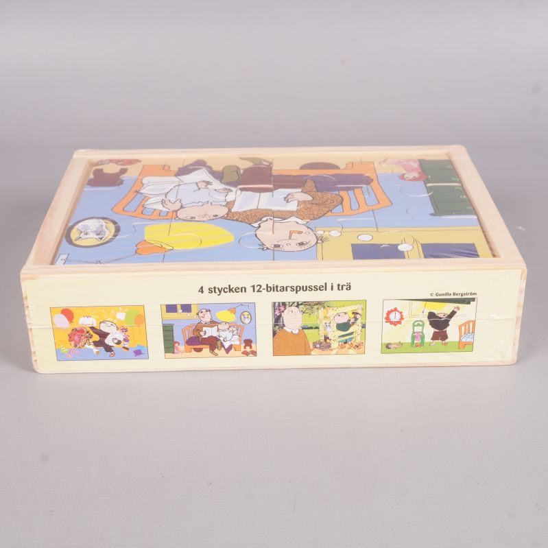 Sida av trälådan med bilder på fyra olika Alfons Åberg pussel