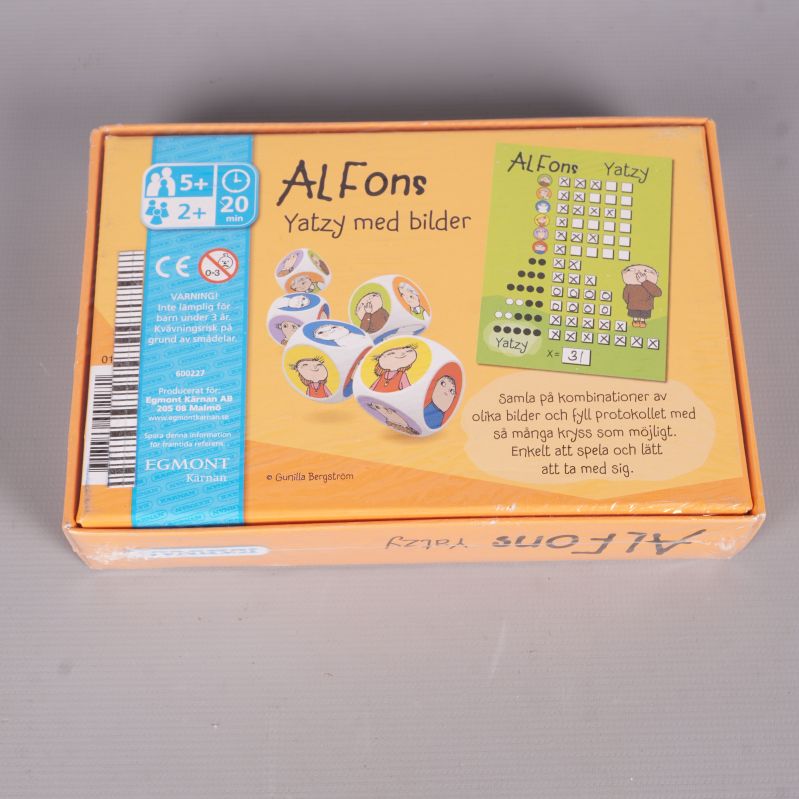 Baksidan av Alfons Yatzy med speldetaljer och bilder på tärningar