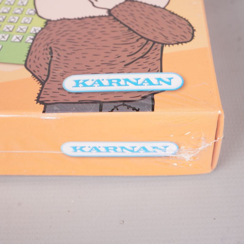 Närbild på hörn av Alfons Yatzy-lådan med logotypen Kärnan