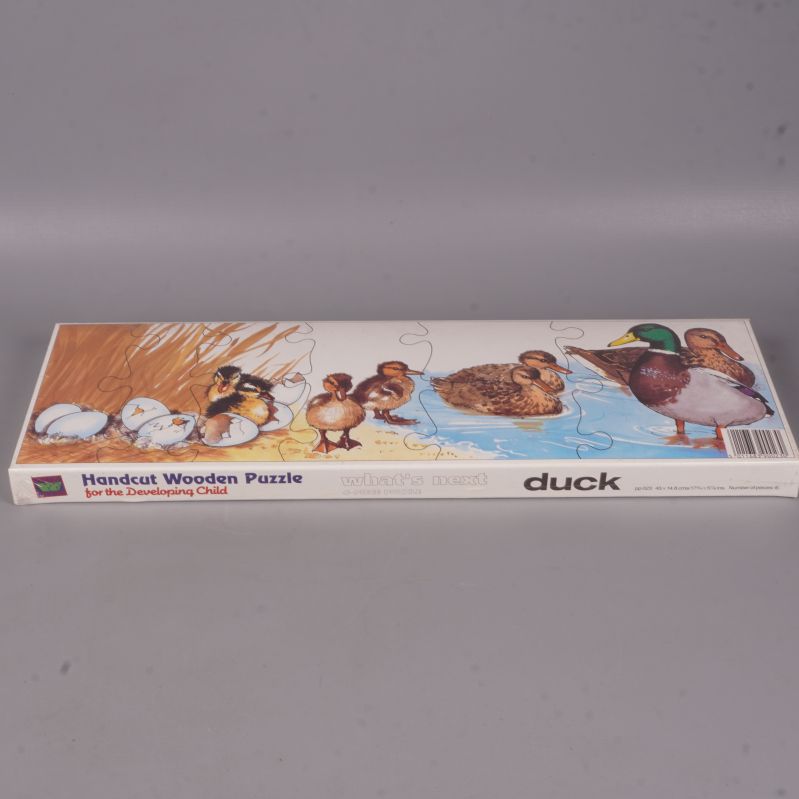 Träpussel i ask med illustration av änder och vatten
