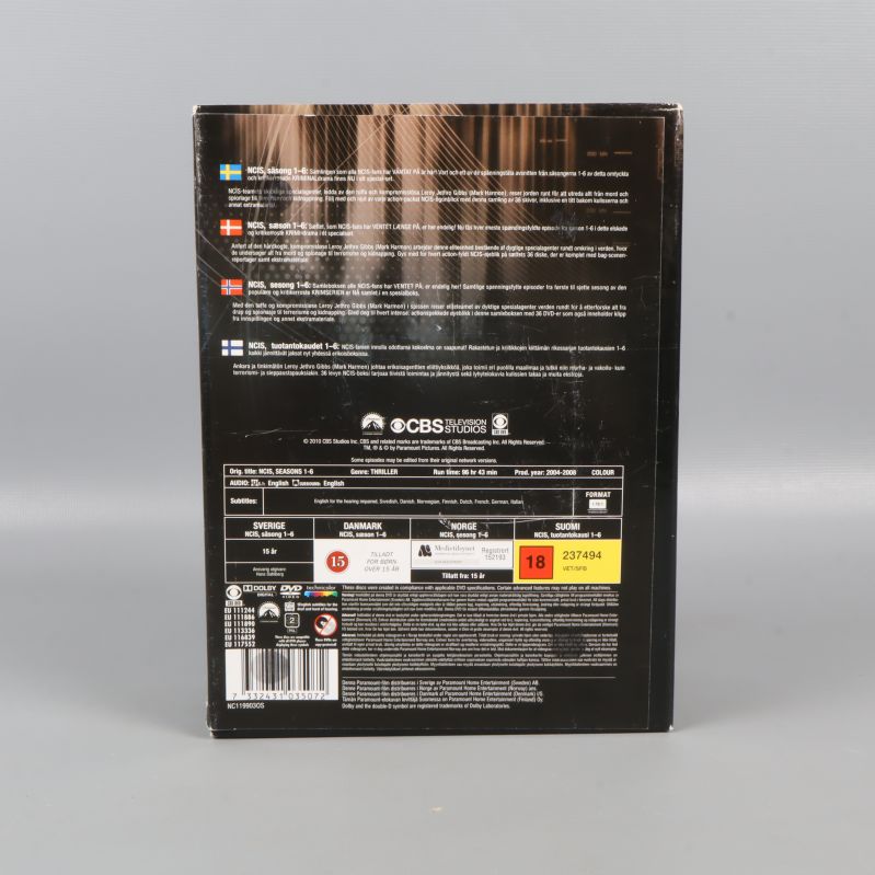 Baksidan på NCIS boxen med text och åldersmärkning