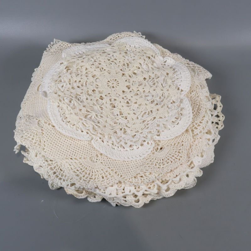 Hög med hopvikta ljusa virkade dukar