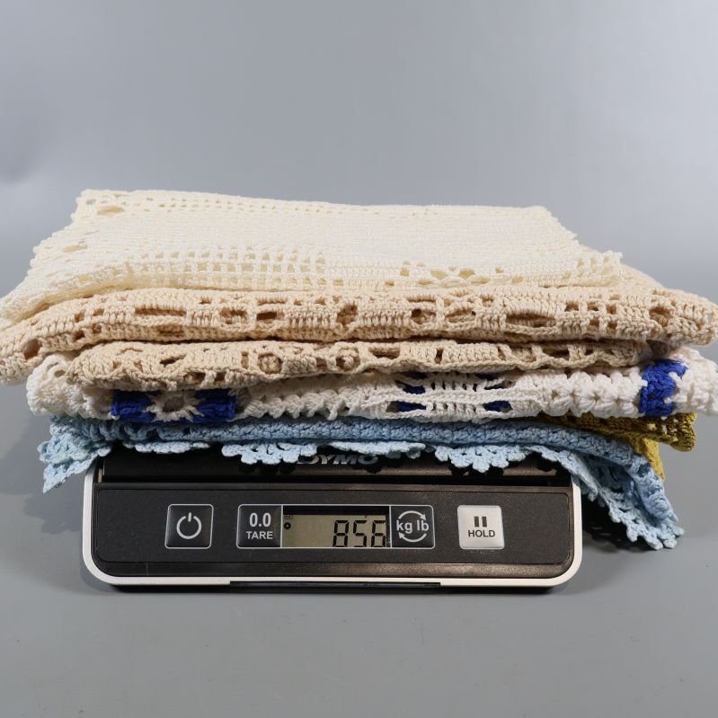 Virkade dukar vägs tillsammans på våg, visar 858 gram