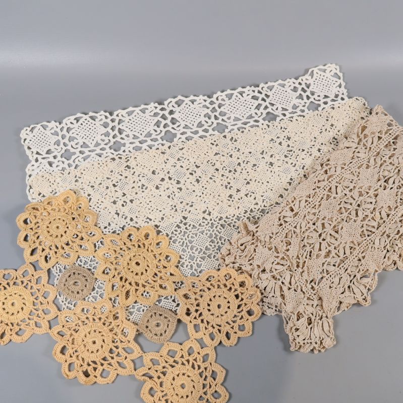 Detaljbild på flera olika virkade dukar i ljusa toner