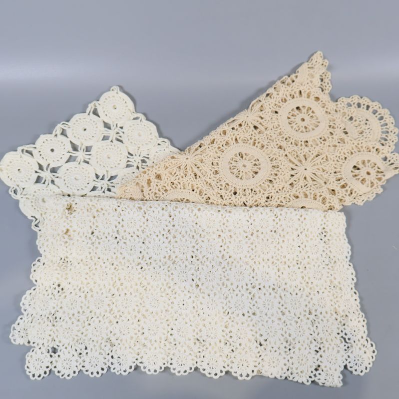 Närbild på två virkade dukar i beige och vitt