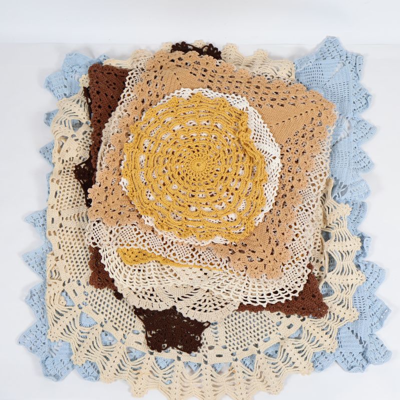 Hög med virkade dukar i olika färger och former