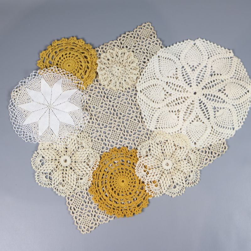 Flera runda virkade dukar i ljusa färger på grå bakgrund