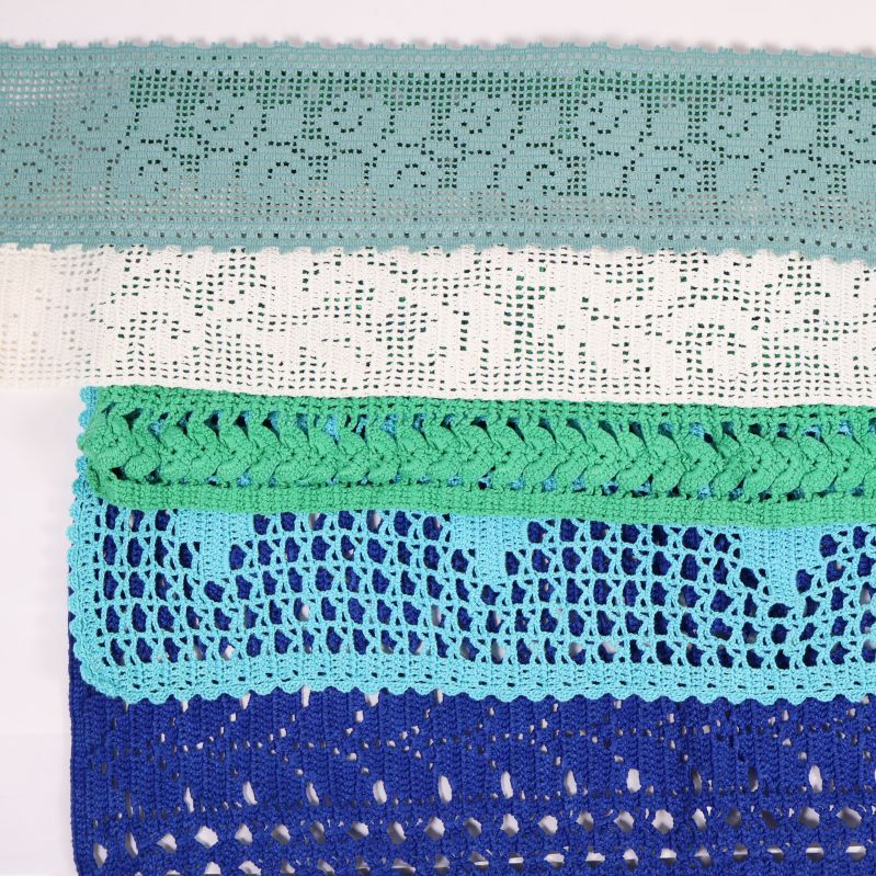 Närbild på virkade spetsar i blått och grönt