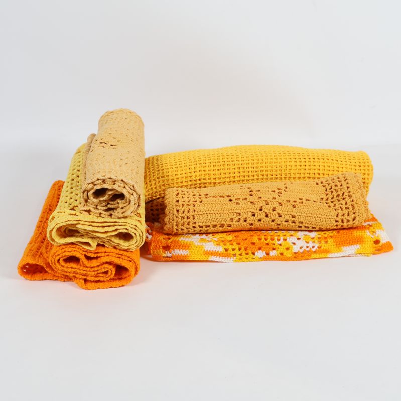 Fyra ihopvikta virkade dukar i gult och orange