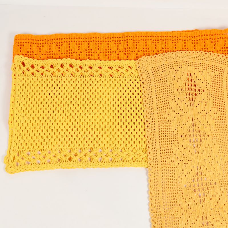 Närbild på två virkade dukar i gult och orange